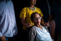 A photo of an elderly woman seated for a portrait with her adult daughter behind her.