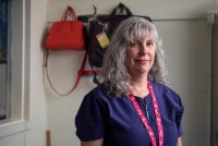 A photo of a school nurse standing by a window in her office.