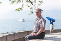 A photo of Jay Comfort sitting by the water outside.