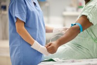 Nurse taking blood from patient in hospital