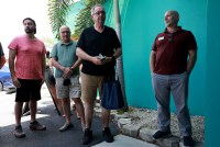 A photo shows men in line outside of a building. They are waiting to get a free monkeypox vaccine.