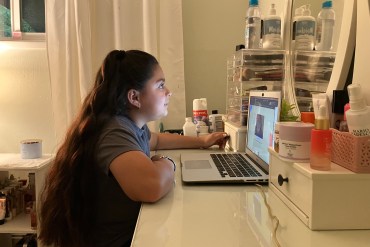 Anjelah Salazar, a fifth grade girl, sits at her desk in front of her computer.